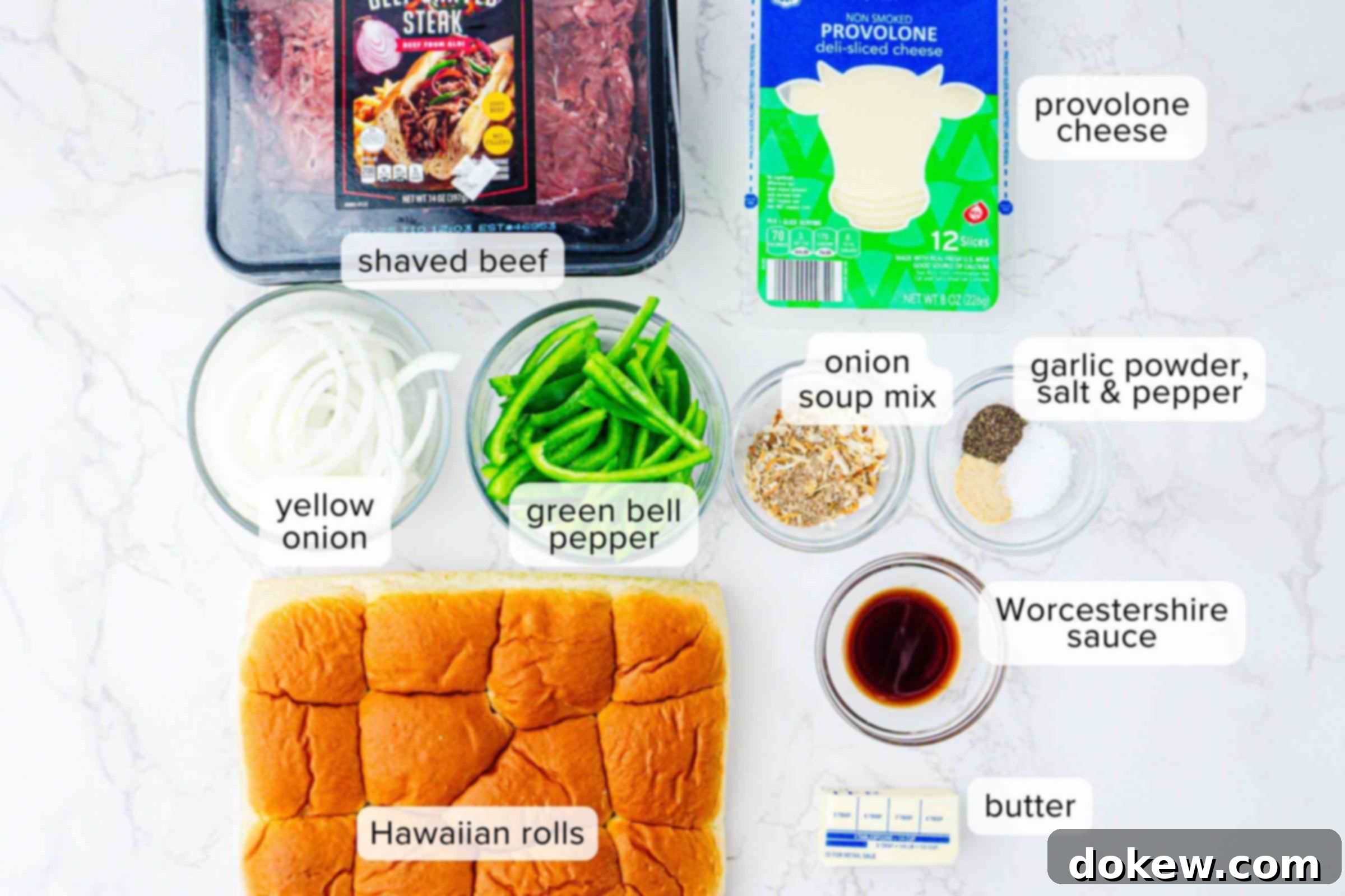 Classic Philly Cheesesteak Sliders 3 Labeled ingredients on a counter: shaved beef, provolone cheese slices, sliced yellow onion, sliced green bell pepper, onion soup mix, garlic powder, salt, pepper, Worcestershire sauce, butter, and Hawaiian rolls.