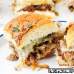 Classic Philly Cheesesteak Sliders 9 Philly cheesesteak sliders arranged on a serving plate.