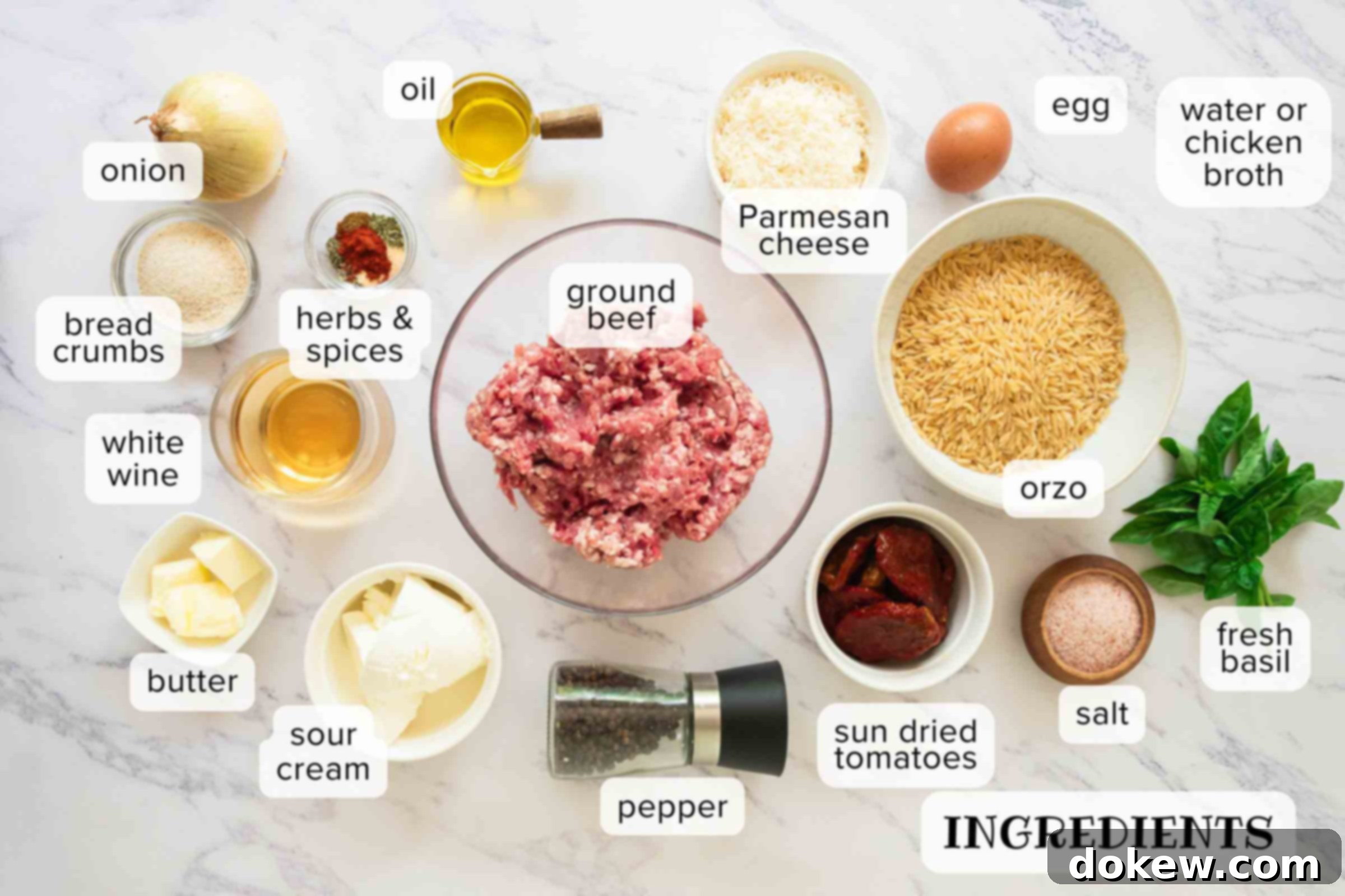 Hearty Tuscan Meatballs with Orzo 3 Labeled ingredients for Tuscan meatballs with orzo: onion, bread crumbs, herbs & spices, white wine, butter, sour cream, pepper, sun-dried tomatoes, salt, fresh basil, orzo, egg, ground beef, Parmesan cheese, oil, and water or chicken broth.