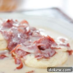 Hearty Chipped Beef Gravy 8 Chipped Beef Gravy and Biscuits on a white plate, showcasing a comforting and delicious meal