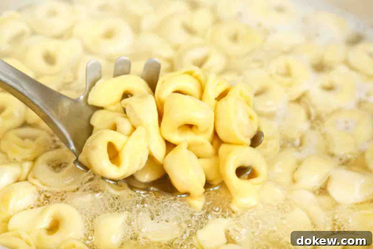 Golden Turkey Tortellini Bake 4 Cheese tortellini boiling in a large pot of water on the stove.