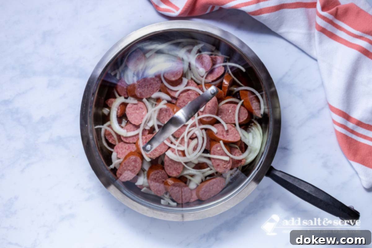 Caramelized Brown Sugar Kielbasa Skillet 5 Covered skillet with sliced kielbasa and onions, in a brown sugar syrup.