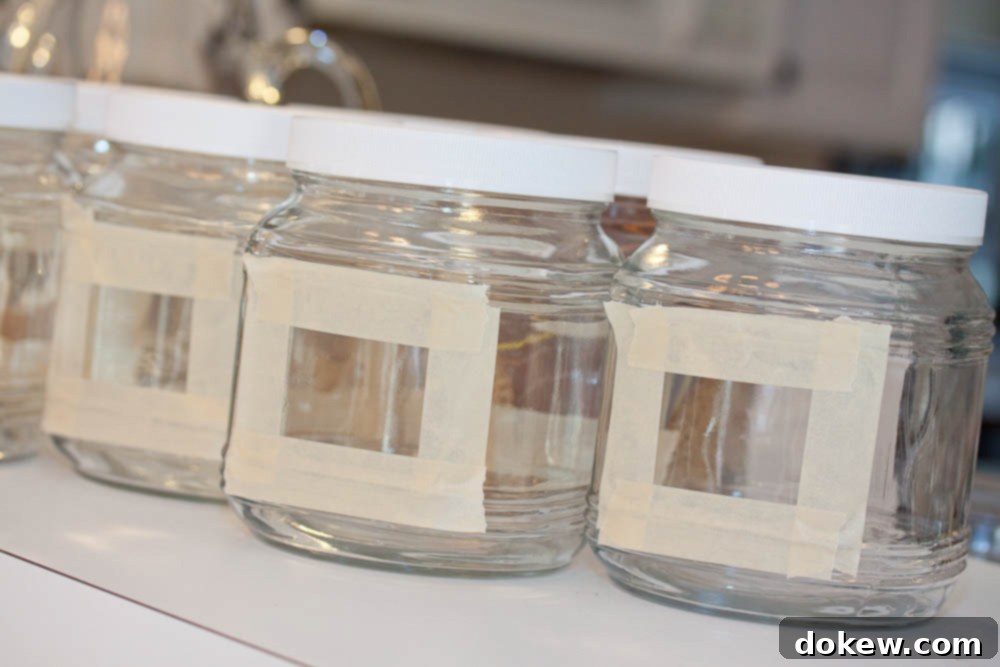 Chalkboard Jar Labels: Quick & Stylish DIY 3 Clear glass jars with rectangles outlined in masking tape, ready for chalkboard paint application