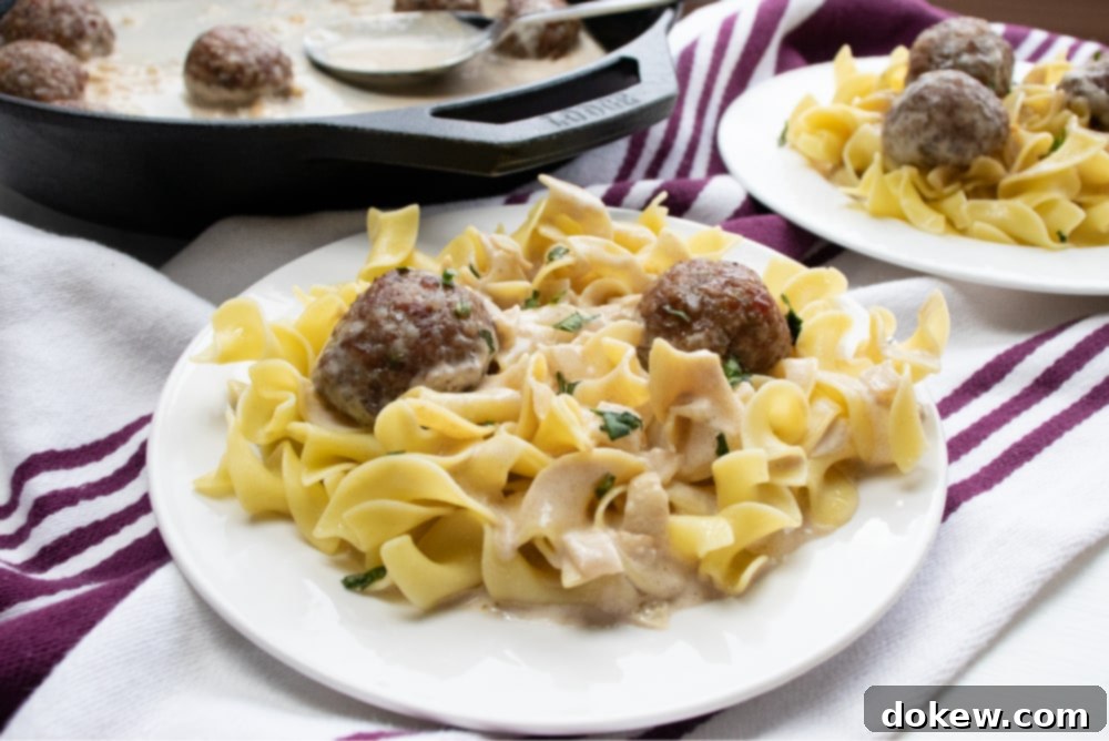 Creamy Balsamic Meatballs Cast iron skillet with chopped onion sautéing and meatballs in a round baking pan to the side