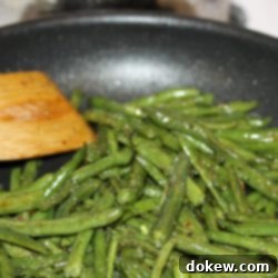 Savory Green Beans 4 Sautéed seasoned green beans in a black frypan