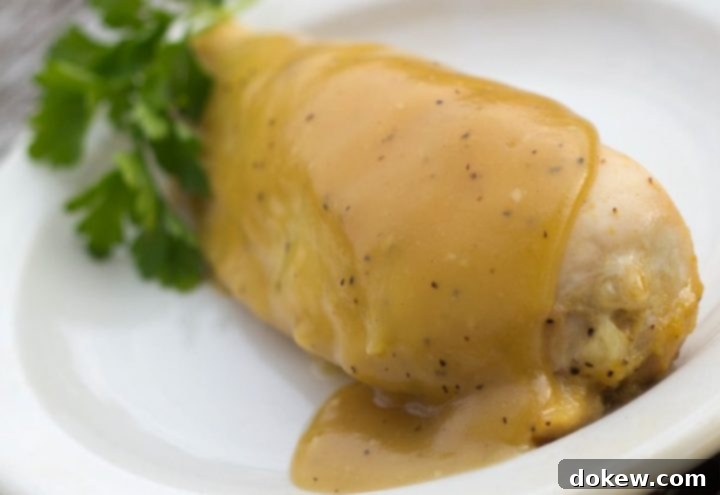 Maple Dijon Chicken White plate with chicken breast topped with a Dijon sauce.