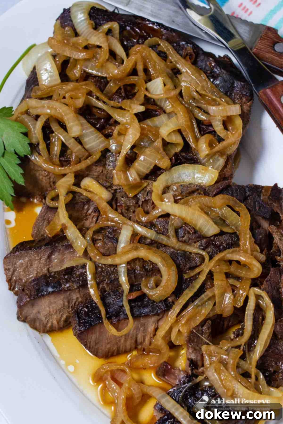 Tender Slow Cooker London Broil in Savory Au Jus 2 Sliced crock pot London Broil with au jus topped with tender onions.