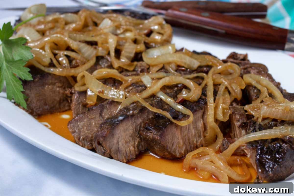 Tender Slow Cooker London Broil in Savory Au Jus 8 Sliced crock pot London Broil with au jus topped with tender onions.