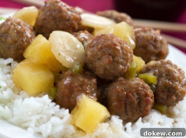 Sweet and Sour Meatballs with Rice Recipe Juicy meatballs, crisp water chestnuts, and sweet pineapple chunks coated in a glossy sweet and sour sauce, served over a bed of fluffy white rice, with text overlay: Sweet and Sour Meatballs #quickandeasy