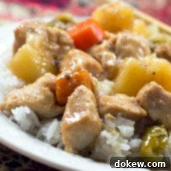 Glazed Sweet and Sour Slow Cooker Chicken 2 Chunks of cooked chicken, pineapple, carrots, and peppers served over white rice