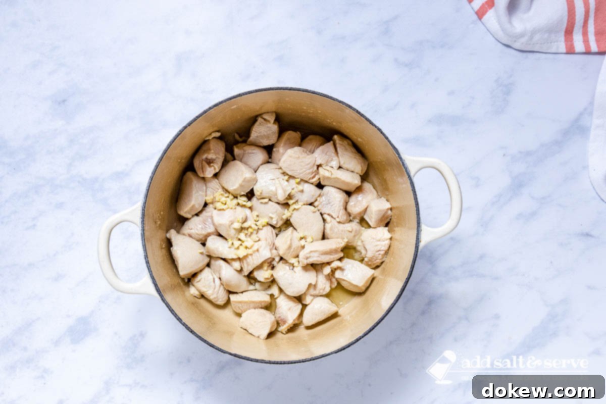 Smoky Southwest Chicken & Corn Chowder 4 Enameled Dutch oven with sautéed chicken and with minced garlic just added.
