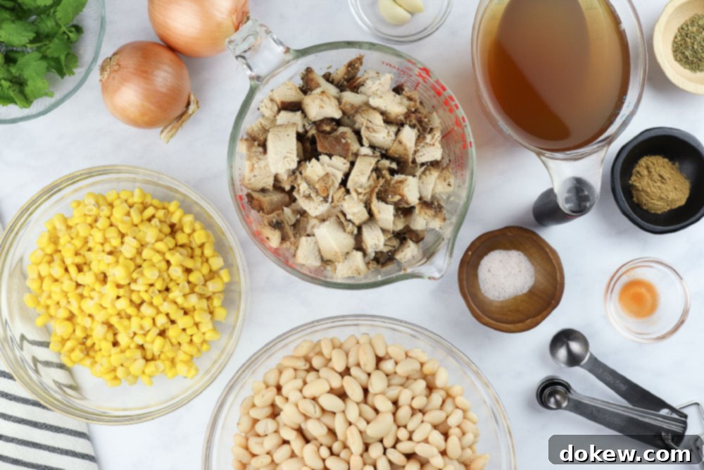 Effortless White Chicken Chili 3 A collection of ingredients for slow cooker white chicken chili, including beans, corn, spices, and chicken.