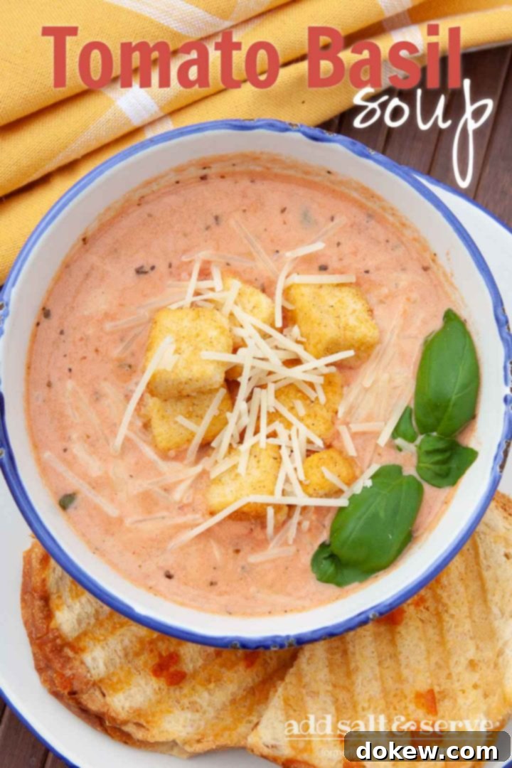 Velvety Tomato Basil Soup 3 Creamy Tomato Basil Soup in a white and blue bowl, topped with croutons and shredded parmesan cheese. The bowl is on a plate with two slices of garlic bread. Text Tomato Basil Soup Add Salt & Serve formerly Menus4Moms
