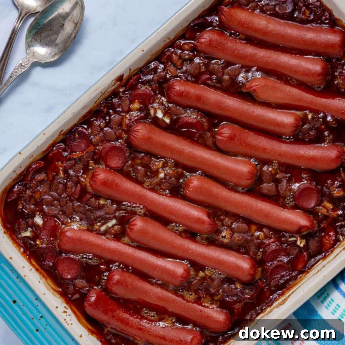 Hot Dog and Bean Bake 2 Baked franks and beans in a baking dish, garnished with parsley.