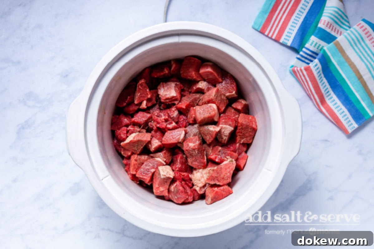 Slow Cooker Tender Beef Guisada 3 Overhead view of beef in a crock pot for Carne Guisada.