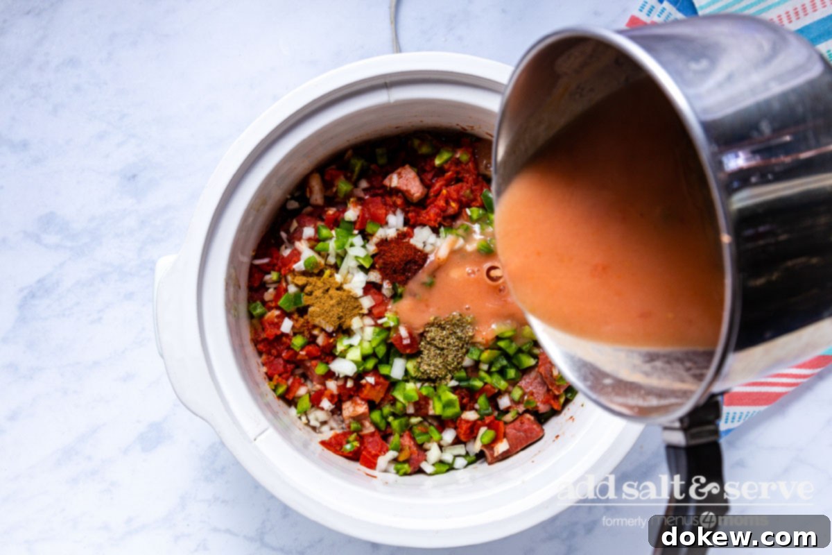 Slow Cooker Tender Beef Guisada 7 Pouring thickened sauce for Carne Guisada over meat, vegetables, and spices in crock pot.