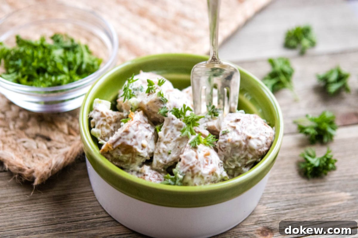 Crimson Roasted Potato Salad 2 Bowl of potato salad with roasted potatoes, garnished with fresh parsley.