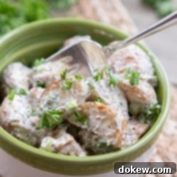 Crimson Roasted Potato Salad 3 Bowl of potato salad garnished with parsley with a fork