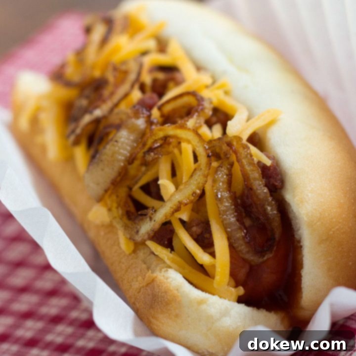 Cowboy Hot Dogs hot dog in bun topped with sauteed onion and grated cheddar cheese.