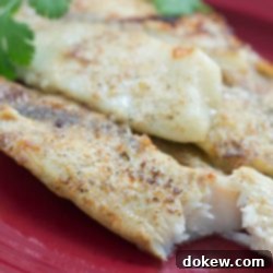 Parmesan-Crusted Tilapia 3 Tilapia fillets on a red plate garnished with parsley