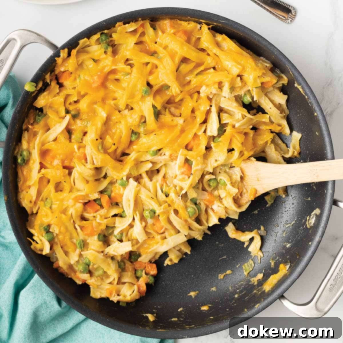 Comforting Tuna Noodle Bake 2 A bubbling, golden-brown cheesy tuna casserole in a cast iron skillet, ready to be served.