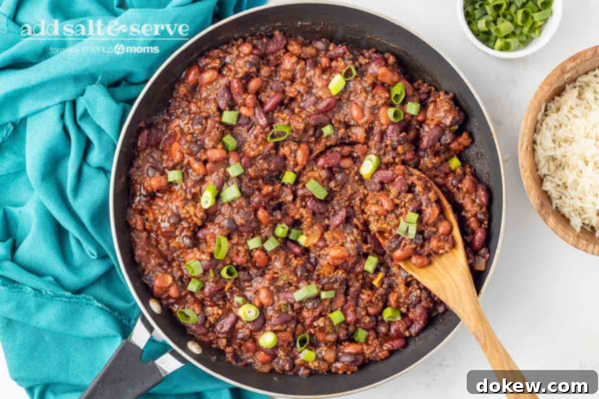 30-Minute BBQ Beef and Beans 6 Close-up of BBQ Beans with Ground Beef garnished with green onion, served in a skillet with a wooden spoon.