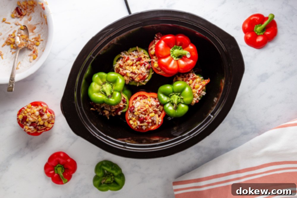 Easy Cheesy Southwestern Stuffed Peppers 6 Stuffed bell peppers nestled inside a slow cooker before cooking begins, promising a delicious meal.