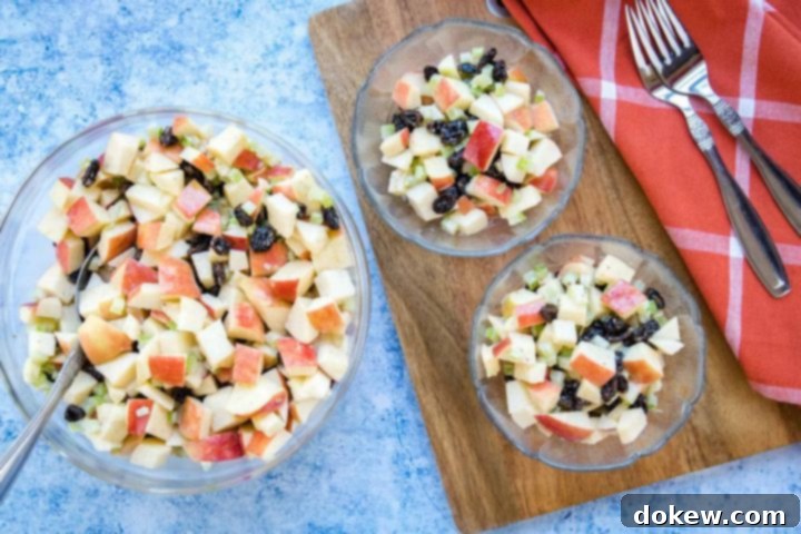 apple-raisin-salad-ip-1-min Overhead view of salad with chopped apples, raisins, and celery with a coral plaid towel and two forks.