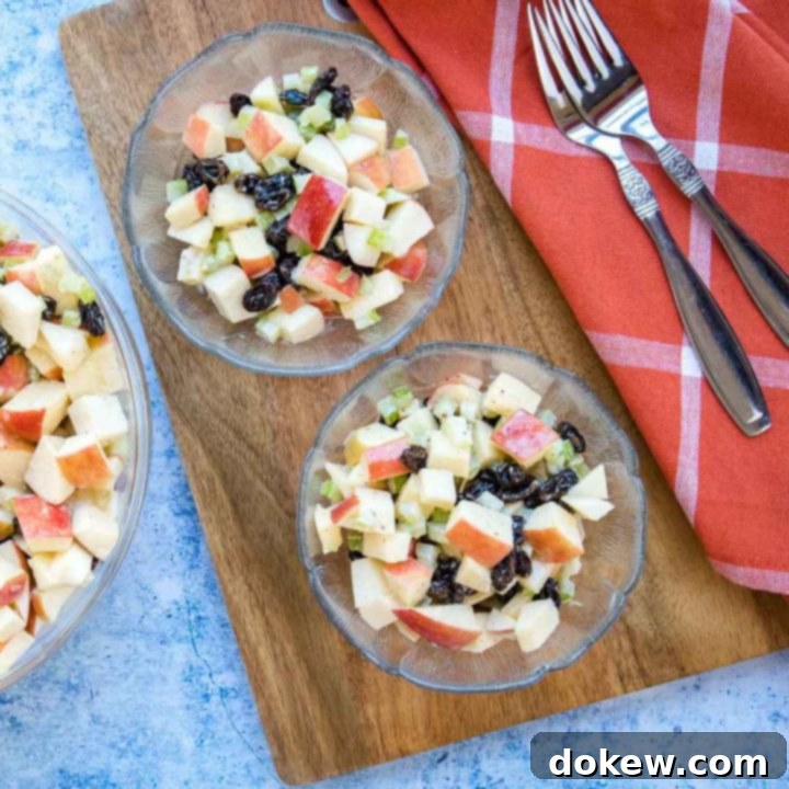 apple-raisin-salad-sq-min-2 Overhead view of salad with chopped apples, raisins, and celery with a coral plaid towel and two forks.